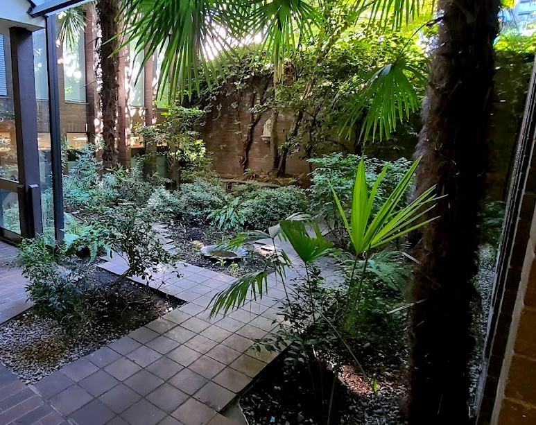 method and metric atrium with lush trees and plants